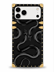 A protective phone case featuring a glossy black background with a raised 3D snake pattern, gold-tone rivets along the border, and gold corner protectors, shown on a white phone against a light gray background.