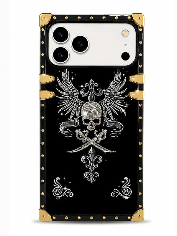 A black phone case with a gothic skull and crossed swords design, embellished with silver rhinestone-style details, featuring gold-tone metal corner protectors and rivets, shown on a white phone against a light gray background.