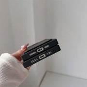 Bottom view of two Noir Card Square iPhone cases showing charging-port and speaker cutouts
