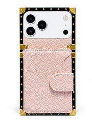 A pink textured leather wallet phone case with a snap-button flap, set against a black frame with gold-tone studs and corner protectors, shown on a white phone against a plain white background.