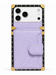 A light purple textured leather wallet phone case with gold-tone metal corner guards and a black studded border, shown on a white phone against a plain white background.