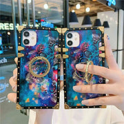 Two mandala print phone cases with a colorful design held by a person in front of a store.
