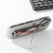 Phone with a stick-on strap stand on a light surface