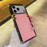 Phone case with pink back and gold accents held by a person.