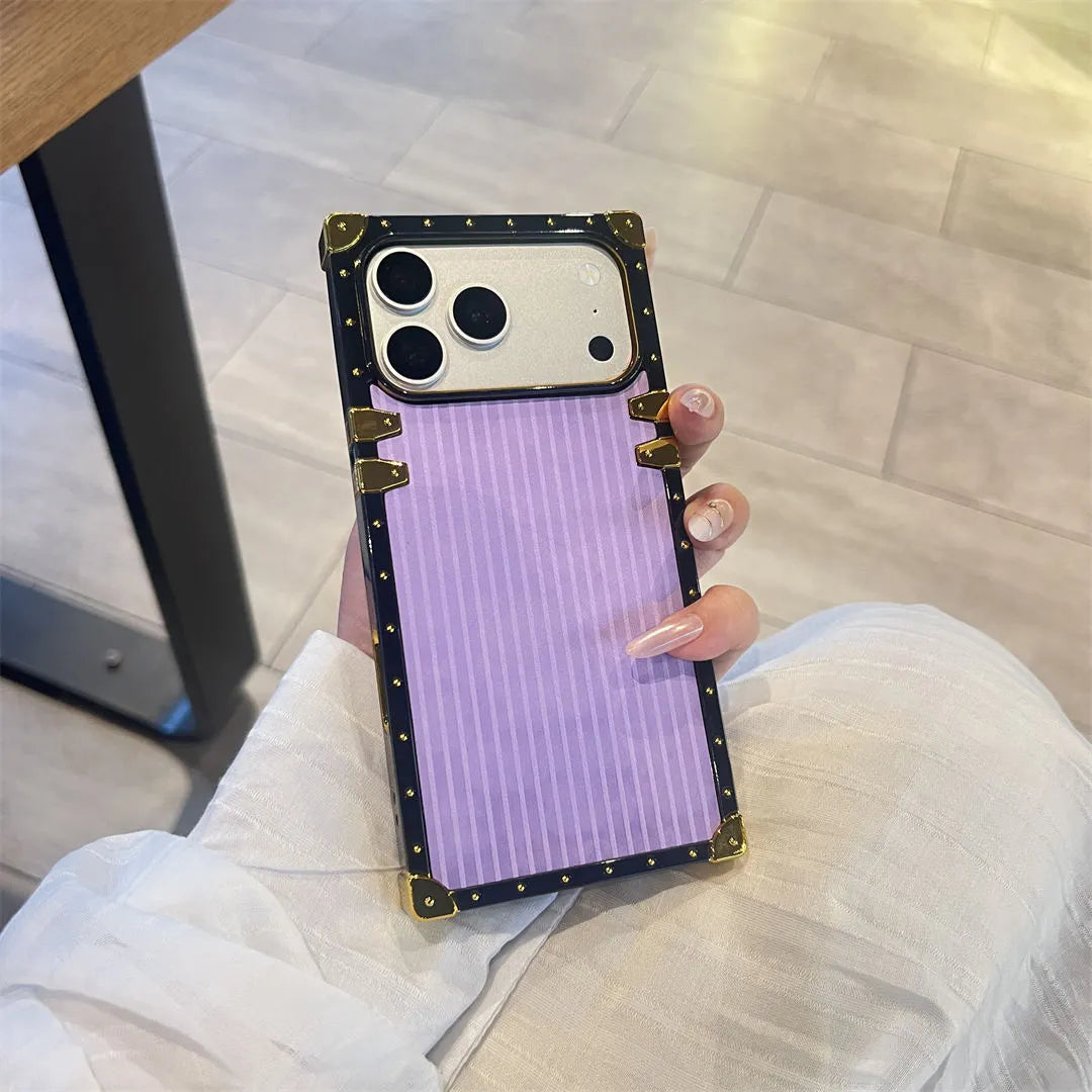 Phone case with a purple design held by a person on a light wooden floor.