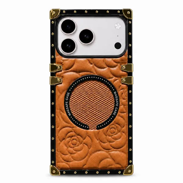 A protective phone case with a brown embossed leather-like floral design, a circular magnetic ring, and a black border with gold-tone rivets and corner protectors, shown on a light gray background.