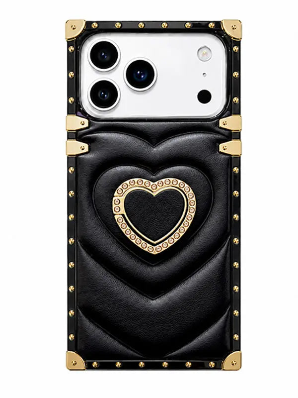 A black quilted leather phone case with gold-tone hardware, featuring a large heart design in the center and a decorative gold border around a smaller heart. The case has a white camera cutout at the top left and is shown on a plain white background.