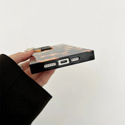 Hand holding a phone case with ports on a light gray background