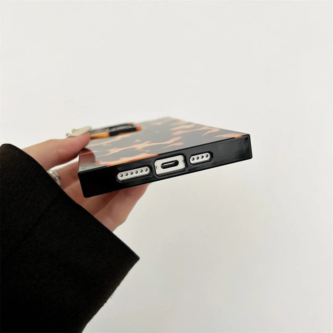 Hand holding a phone case with ports on a light gray background