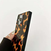 Phone case with tortoiseshell pattern held by a hand on a white background