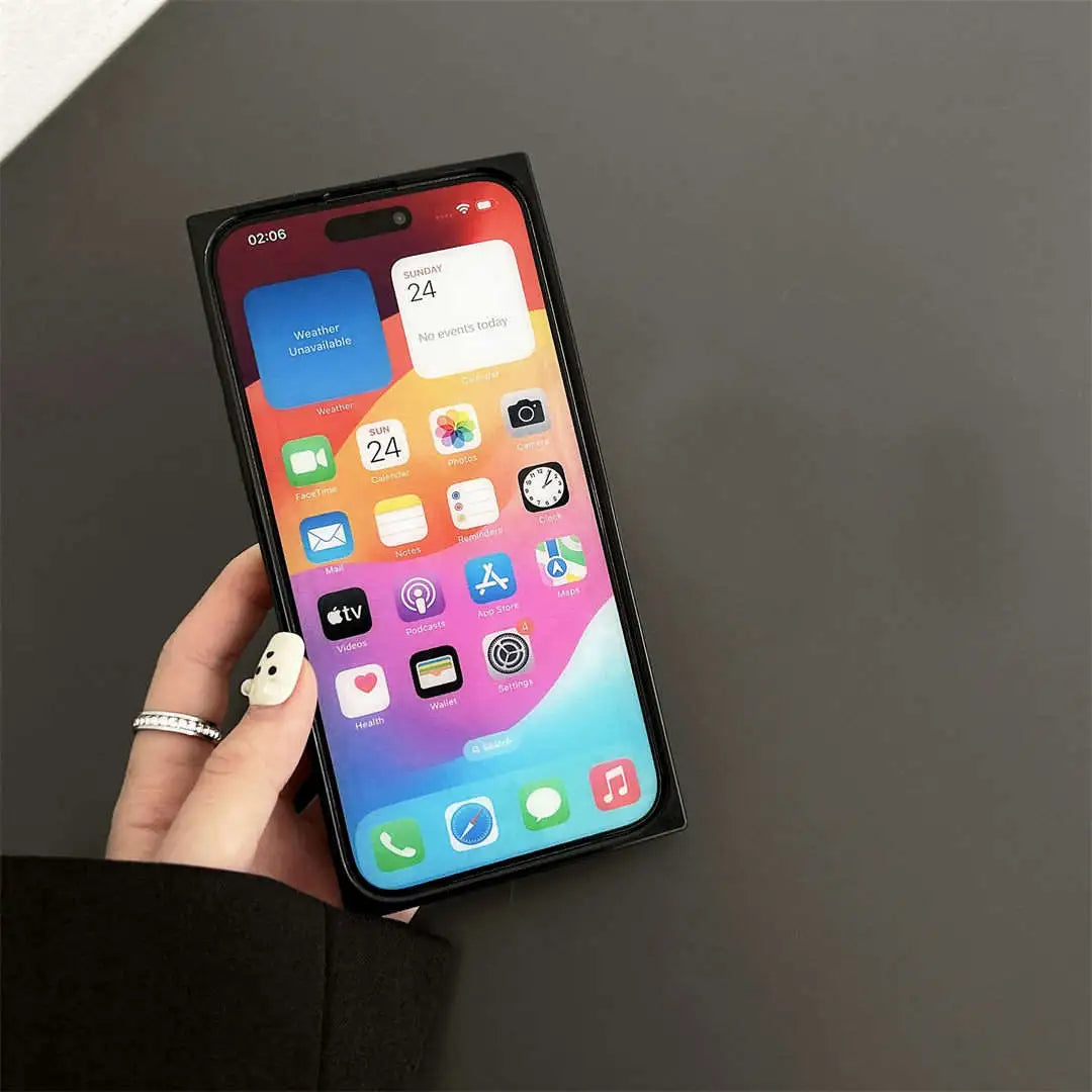 Smartphone with a colorful display held by a hand on a dark surface