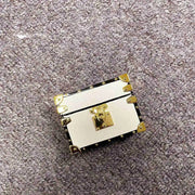 white leather AirPods coverwith gold accents on a textured gray surface