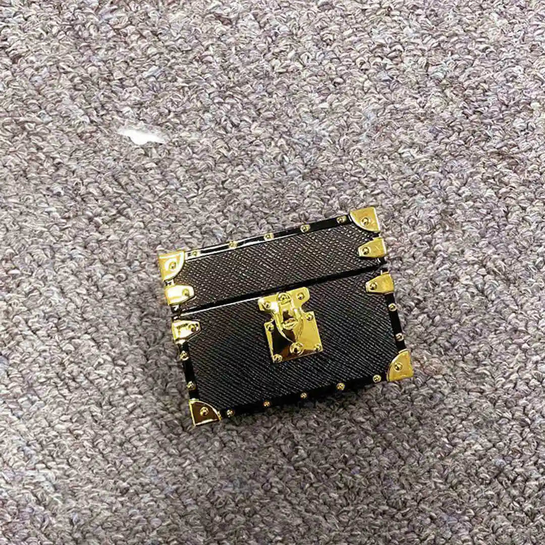 black leather AirPods cover with gold accents on a gray carpet