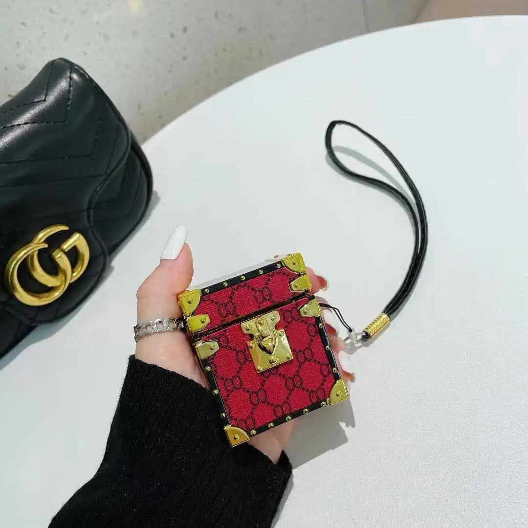 Red AirPods trunk cover held by a hand with a black background