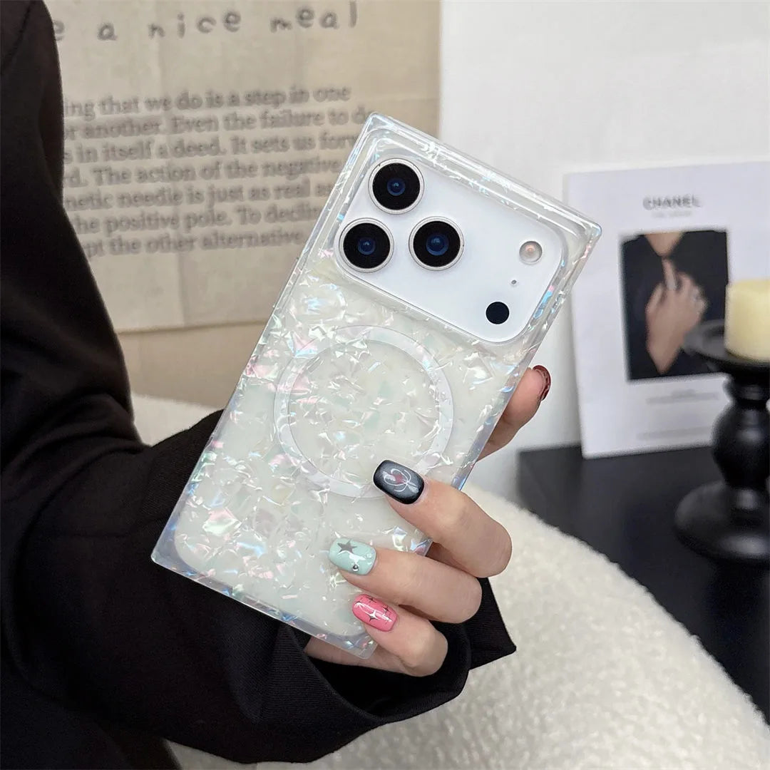 Person holding a phone with a glittery case in front of a magazine