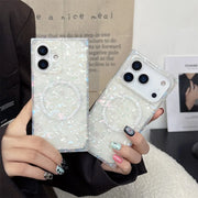 Person holding two phone cases with glittery opal shell design.
