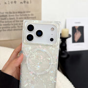 Phone case with glittery opal shell design held by a hand, blurred background