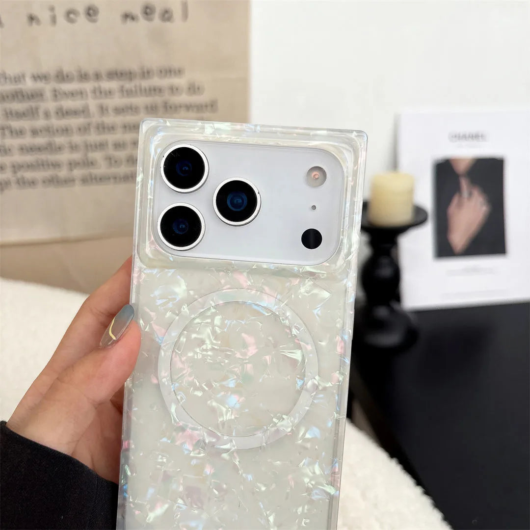 Phone case with glittery opal shell design held by a hand, blurred background