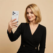 Woman in a black outfit holding a phone in opal shell case with a beige background